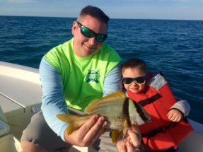 Father & Son holding a Porkfish